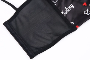 Detailed macro view of black satin fabric with Darling text and mesh lace stitching