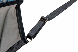 Detail of adjustable black lingerie straps with gold metal hardware and lace embroidery