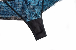Macro shot of deep blue floral lace and black mesh fabric on sexy thong underwear