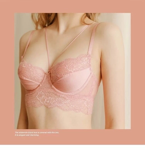 Detail of pink lace bra featuring delicate floral embroidery and dual thin straps