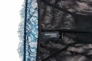 Detailed close-up of blue eyelash lace and sheer black mesh with size M label