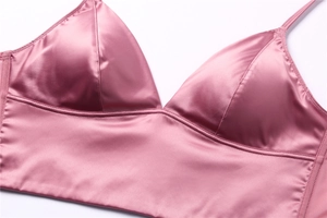 Detail view of pink satin bralette featuring premium stitching and smooth silk fabric