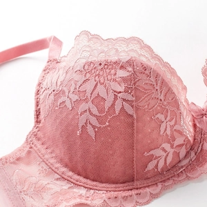 Gros plan sur la dentelle florale rose clair et le mesh respirant de ce soutien-gorge