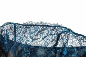 Close-up of deep teal floral lace with delicate eyelash lace fringe details