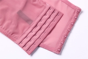 Detailed macro shot of four-row adjustable hook and eye closure on pink lace bra