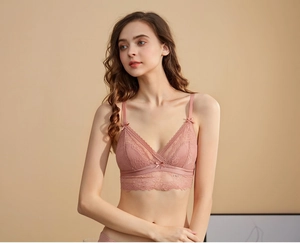 Détail de la bralette triangle en dentelle rose poudré avec motifs floraux et fines bretelles
