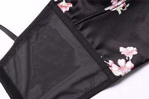 Detail of pink cherry blossom print on black satin fabric with delicate mesh stitching
