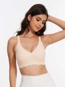 Front view of beige seamless wireless bra featuring wide straps and scalloped edge detail