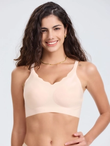 Détail d'un soutien-gorge sans couture rose pâle avec bords festonnés et tissu mat doux
