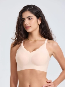 Détail de brassière sport sans coutures couleur chair avec bord ondulé et tissu élastique