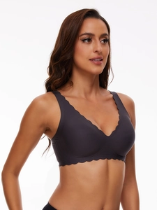 Close-up of seamless dark grey bra featuring wide straps and laser-cut wavy edges