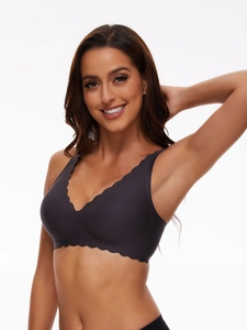 Detail of seamless deep V-neck bra with scalloped edges in dark grey elastic fabric