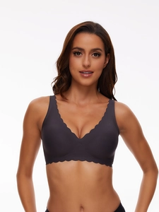 Close-up of seamless dark purple wireless bra with scalloped edges and elastic fabric