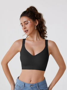 Close-up of black seamless sports bra featuring wide elastic hem and soft V-neck design