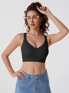 Seamless black sports bra with wide straps and jelly-strip support on a female model