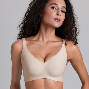 Detail of a beige seamless wireless sports bra with a deep V-neck and wide shoulder straps