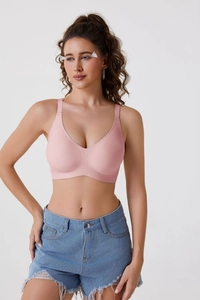 Vue de face du soutien-gorge sans couture rose poudré avec larges bretelles et lisses