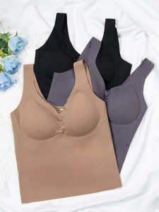 Close-up of seamless elastic sports bras in black, grey, and brown with droplet pads