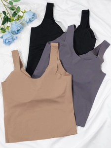 Three seamless tank tops in black, dark grey, and khaki on white satin fabric