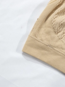 Detail of light brown ribbed hem and cable knit texture on nursing bra fabric