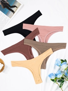 Flat lay of five seamless ribbed thongs in assorted earth tones on white fabric background