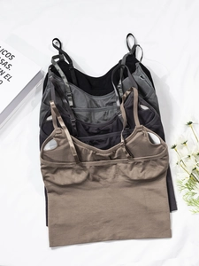 Flat lay of four seamless ribbed camisoles in neutral tones with adjustable straps