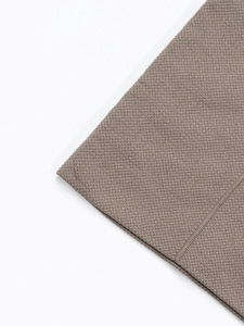 Close-up of brown seamless knitted fabric showing detailed honeycomb mesh texture