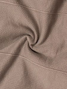 Macro shot of dark khaki seamless knitted fabric texture with waffle weave pattern