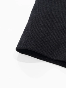 Close-up of black seamless honeycomb knitted fabric with elastic textures and neat seams