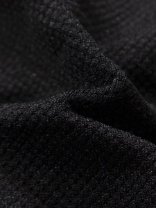 Close-up of black seamless knitted fabric showing high-density breathable honeycomb texture