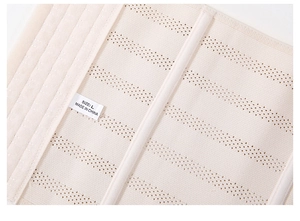 Close-up of breathable mesh fabric and support bars on beige waist trainer belt