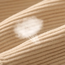 Close-up of beige ribbed knit fabric showing breathable texture and soft material