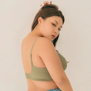 Macro detail of avocado green seamless bra showing U-shaped low back and thin straps