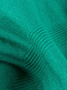 Macro detail of breathable ribbed knit fabric texture on men's teal boxer briefs