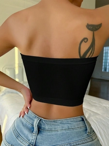 Detail of black seamless ribbed tube top showing backless knit design on model