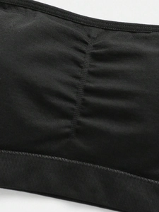 Close-up of ruched center detail and elastic knit fabric on black strapless bra