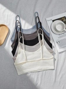 Flat lay of seamless ribbed camisoles in five neutral colors with soft textures