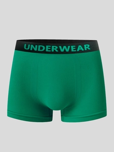 Detail view of green ribbed boxer briefs featuring a black elastic waistband with lettering