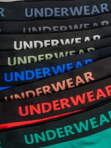 Detail of multi-color elastic waistbands with UNDERWEAR letter print on men's boxer briefs