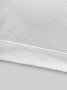 Macro view of flat stitched hem and fine cotton texture on girls' white bandeau top