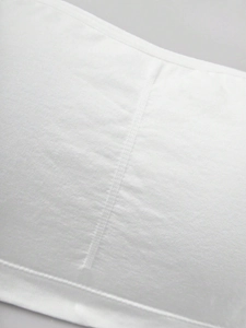 Macro detail of white seamless tube top bra with fine ribbed texture and elastic seams