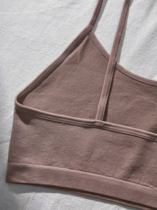 Detail of seamless ribbed teen bra in lotus pink with thin straps and elastic hem
