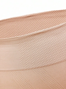 Detailed macro view of seamless high-elasticity fabric and waistband on beige body shaper