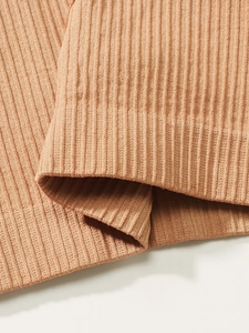 Detailed macro view of the seamless camel ribbed knit fabric with elastic texture