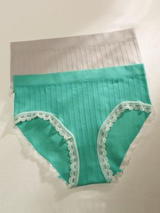 Detailed macro view of mint green and grey ribbed cotton panties with delicate lace trim