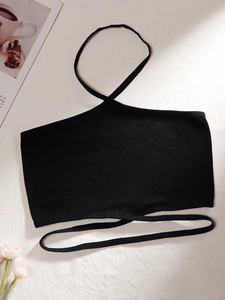 Détail de la brassière noire en maille côtelée avec licou et fines bretelles