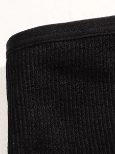 Gros plan sur un tissu noir côtelé sans couture montrant la texture élastique et couture