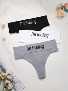 Detailed view of 3-pack seamless cotton thongs in black, white and grey with lettering