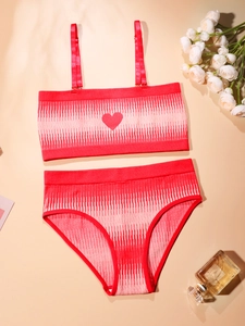 Flat lay of seamless red knitted lingerie set with heart motif and wave texture