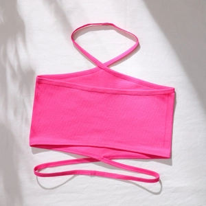Détail d'un haut bandeau en maille côtelée rose fluo avec licou croisé et liens noués
